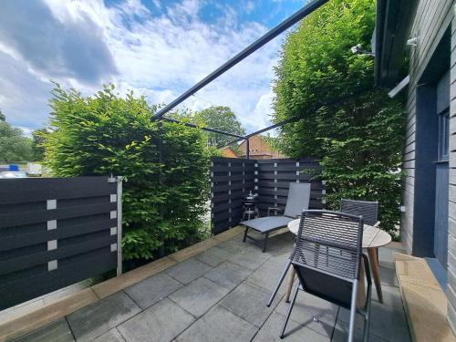 a patio with a table and chairs and a fence at Ferienwohnungen Leber in Bad Neustadt an der Saale