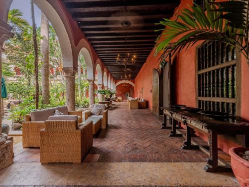 a room with chairs and a piano in a building at Sofitel Legend Santa Clara Cartagena in Cartagena de Indias