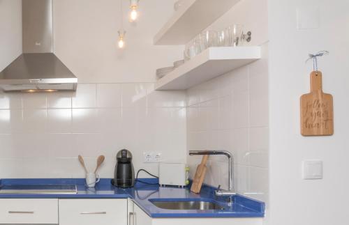 una cucina bianca con lavandino e aaucet di Home Sweet Apartments a Lisbona