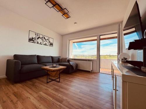 a living room with a couch and a large window at Ferienwohnung BEST VIEW Brilon in Brilon