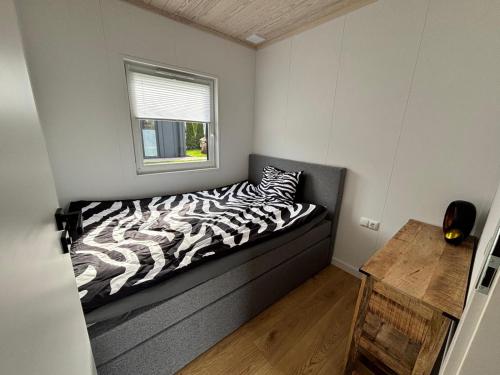 a zebra print bed in a small room with a window at Fernblick- Sauna- WLAN- Haus 2 in Neheim-Hüsten