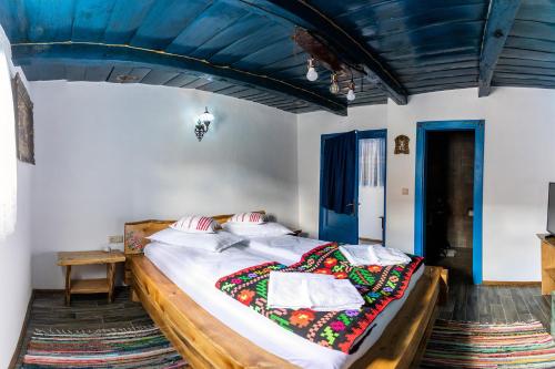 a large bed in a room with a blue ceiling at CASA HAIDUCILOR Green Codru in Codru