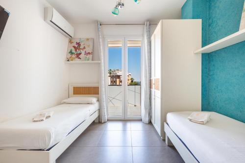 two beds in a room with a window at B&B Acquamarina in Gallipoli