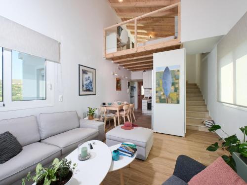 a living room with a couch and a table at Gaea Loft Villa - 1st Floor in Kokkini Khanion