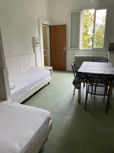 a bedroom with two beds and a table and a window at Gîte de la cathédrale in Condom