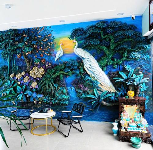 a mural of peacocks on a wall in a room at Victoria Hostel Huế in Hue