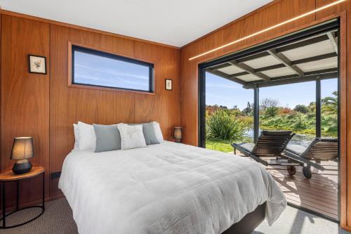 a bedroom with a large bed and a balcony at Relaxing Getaway in Pohara in Pohara