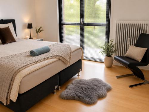 a bedroom with a bed and a chair and a rug at Stor 2 værelses lejlighed in Randers