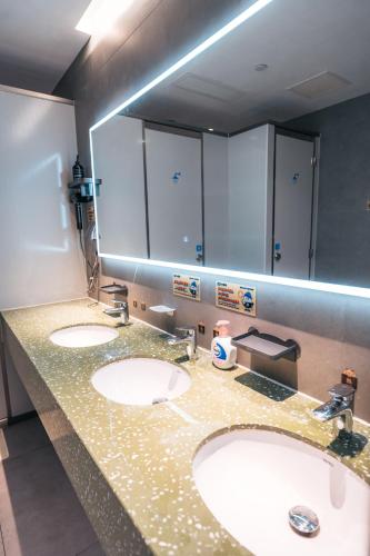 a bathroom with two sinks and a large mirror at F18 Hub Youth Hostel in Chengdu