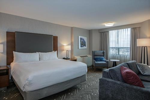 a hotel room with a bed and a chair at DoubleTree by Hilton West Edmonton in Edmonton