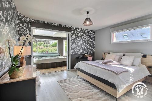 ein Schlafzimmer mit einem Bett und einem Fenster in der Unterkunft La suite orchidée in Paimpol