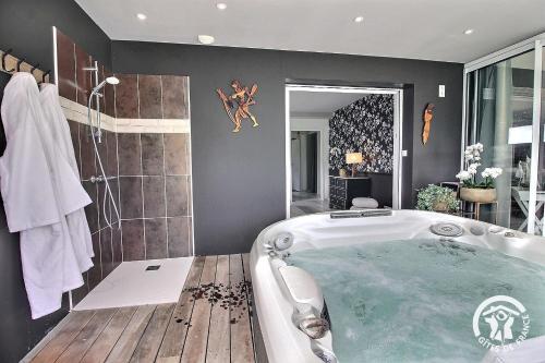 ein Badezimmer mit Badewanne und Dusche in der Unterkunft La suite orchidée in Paimpol
