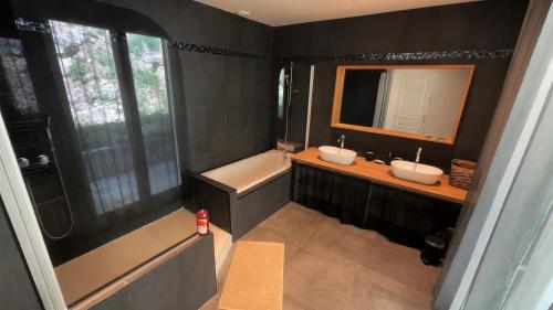 a bathroom with two sinks and a tub and a mirror at Villa d'exception avec grande terrasse et piscine in Mons