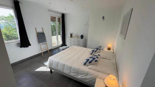 a white bedroom with a bed and a window at Villa d'exception avec grande terrasse et piscine in Mons