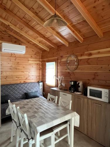 a dining room with a table and a kitchen at Chalet 4 personnes in Foix