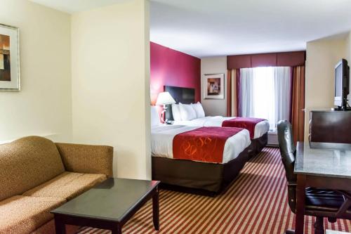 a hotel room with a bed and a couch at Comfort Suites Palm Bay - Melbourne in Palm Bay
