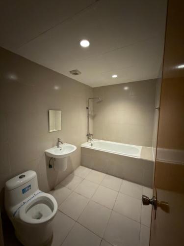 a bathroom with a toilet and a bath tub at Nice Hotel Monumento in Manila