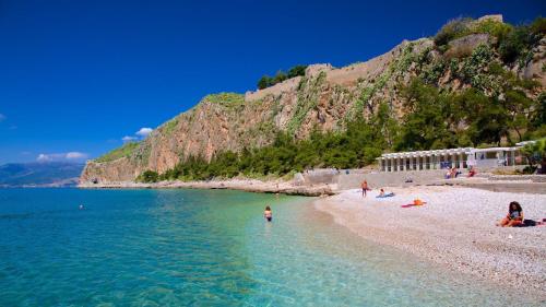 a group of people on a beach in the water at Chrysiida Luxury Apt, Stroll to Nafplio Center in Nafplio