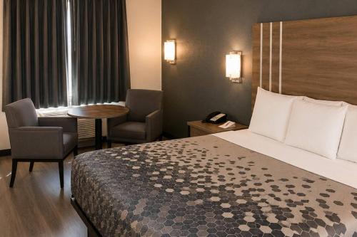 a hotel room with a bed and a table and chairs at Econo Lodge Calhoun South in Calhoun