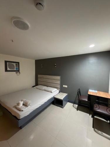 a bedroom with a bed and a desk in it at Nice Hotel Monumento in Manila