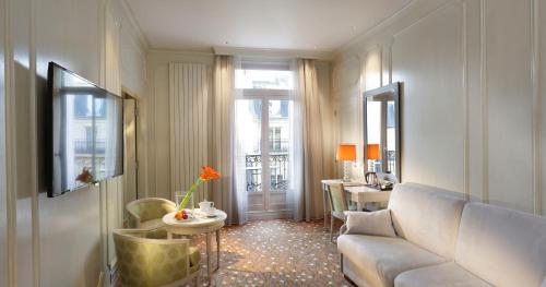 Hôtel Château Frontenac في باريس: غرفة معيشة مع أريكة وطاولة