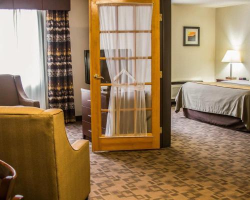 a hotel room with a door leading to a bed at Comfort Inn Birch Run - Frankenmuth in Birch Run