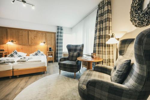 a hotel room with a bed and a couch and a chair at Hotel Lauterbad in Freudenstadt