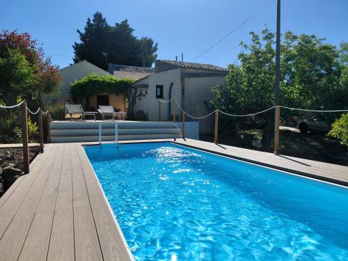 a large blue swimming pool with a wooden deck at Anastè in Buseto Palizzolo