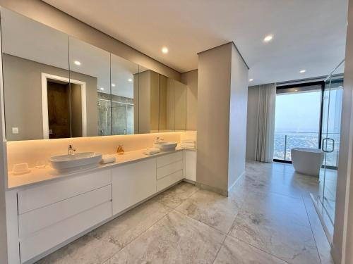 a bathroom with two sinks and a large mirror at The Leonardo in Johannesburg