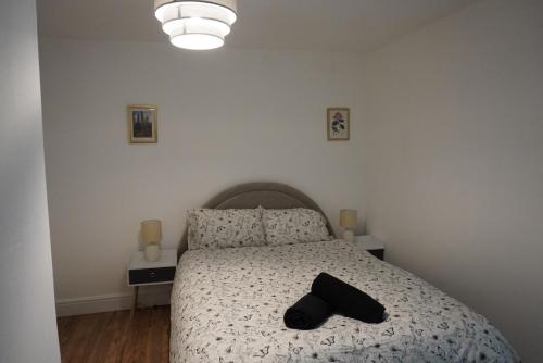 a bedroom with a bed with a black hat on it at Garden flat seafront Hastings in Hastings
