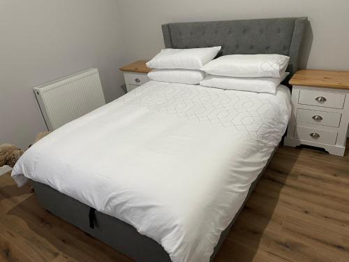 a bedroom with a bed with white sheets and pillows at Killyfole lakeside lodges in Corranny
