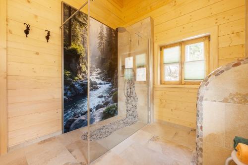 a bathroom with a shower with a painting on the wall at Chalet Vogelnest am Waldbach in Reit im Winkl