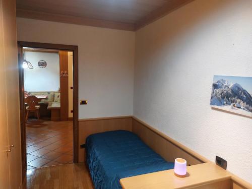 a room with a bed and a table and a door at Il Nido casa vacanze in Varena