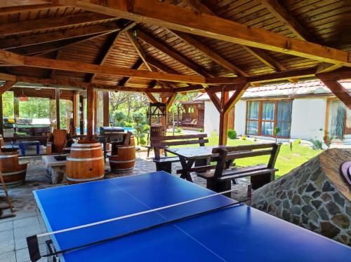 a patio with a ping pong table and benches at Virág Vendégház in Hercegkút