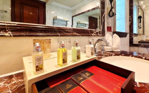 a bathroom with a sink and two bottles of soap at Grand Concordia Hotel in Beijing