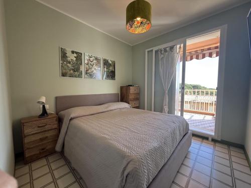 a bedroom with a bed and a large window at Capo d'Arco - Bougainvillea in Capo D'Arco