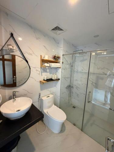 a bathroom with a toilet and a sink and a shower at MoonKing FLC Sầm Sơn in Sầm Sơn