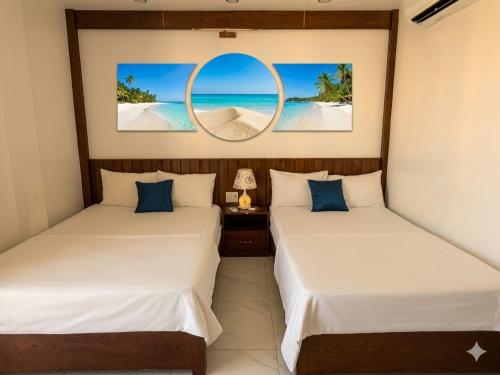 two beds in a room with a mirror at MoonKing FLC Sầm Sơn in Sầm Sơn
