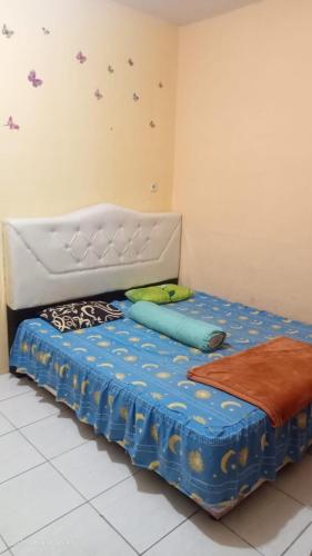 a small bed in a room with a blue bedsheet at Villa Raisya Berastagi in Berastagi