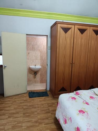 a bedroom with a bed and a sink in a room at Villa Raisya Berastagi in Berastagi