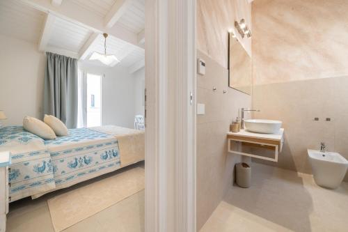 a bathroom with a bed and a sink in a room at Borgo Myricae - Giglio in Chia