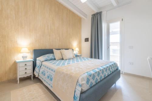 a bedroom with a large bed and a window at Borgo Myricae - Giglio in Chia