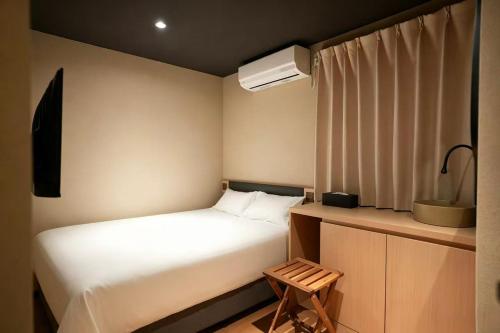 a small bedroom with a white bed and a window at SORA雷門 Hotel in Tokyo