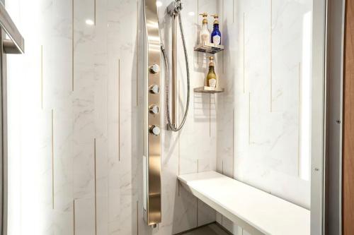 a shower in a bathroom with white tiles at SORA雷門 Hotel in Tokyo