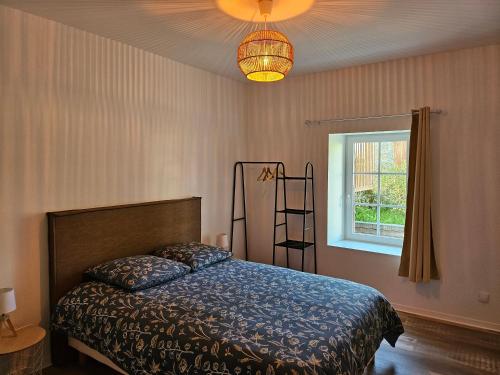 a bedroom with a bed and a lamp and a window at Les Gîtes de Guillonnet in Anglade