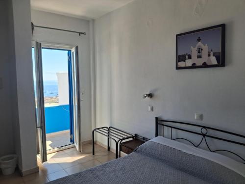 a bedroom with a bed and a view of the ocean at Villa Firostefani in Firostefani