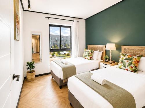a hotel room with two beds and a window at ZALS- Nine Palms -Luxury Two Bed in Cape Town