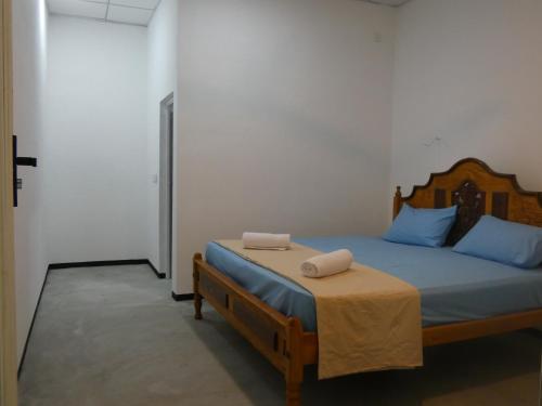 a bedroom with a bed with two towels on it at Mango Surf House in Arugam Bay