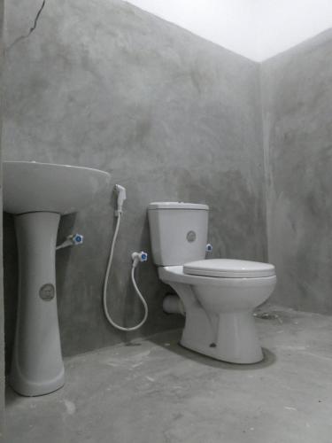 a bathroom with a toilet and a sink at Mango Surf House in Arugam Bay