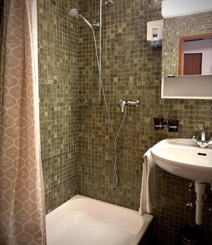a bathroom with a shower and a sink at Hotel Fiescherhof in Fiesch